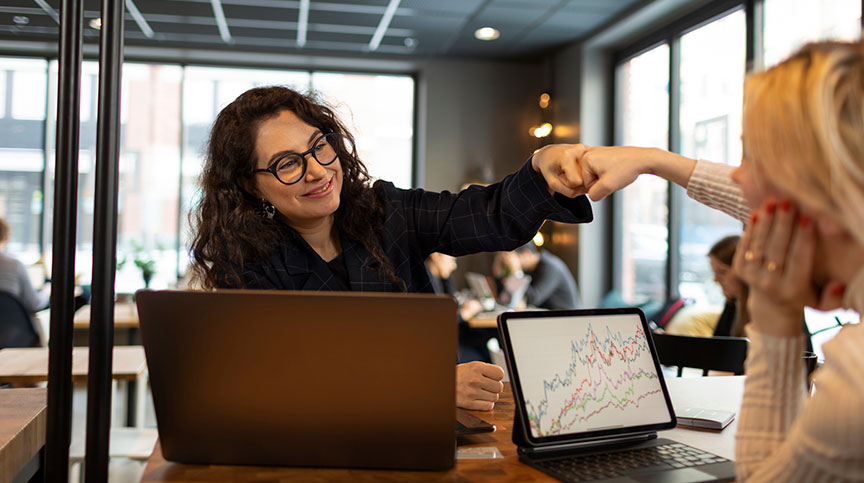 Photo of women fist-bumping about building high performing teams, while being cautious about the too-much-talent effect and using CCL's Team Effectiveness Framework