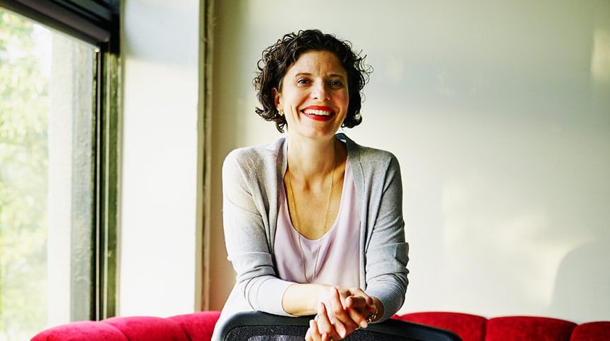 Woman smiling thinking about the benefits of leadership development and how it powers engagement and retention white paper