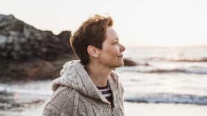 Woman looking off in the distance considering the keys to wellbeing and leadership along with the importance of employee wellbeing