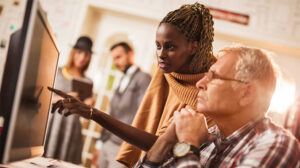 Older man and younger woman discussing leading a Multigenerational Workforce or team and leading across generations