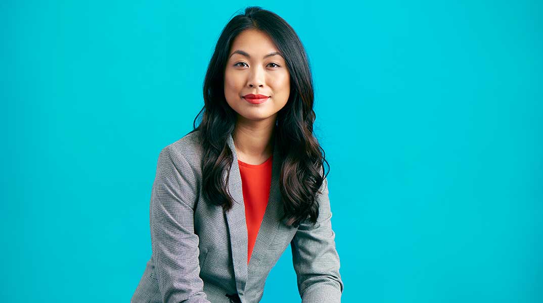 portrait of woman against blue background representing mentorship for women and the need for sponsorship in the workplace