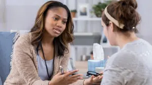 two women talking holding important conversations about race in the workplace