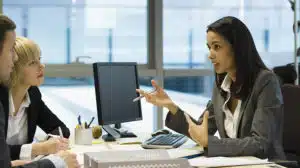 photo of women discussing what teams need to succeed and 3 team needs that must be addressed to improve team performance