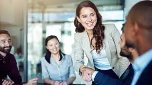 colleagues in office shaking hands and showing critical need to sponsor women in the workplace